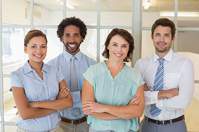 4 people standing up with their arms crossed two men and two woman with business atire
